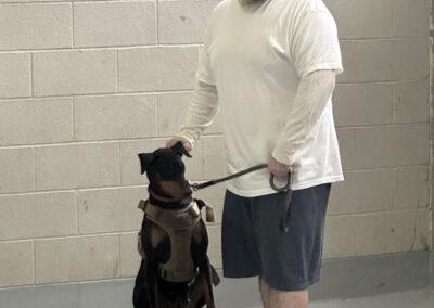A man holding a leash with a dog on it