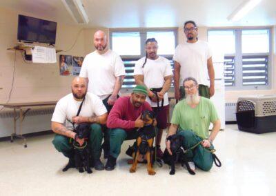a group of people posing with dogs